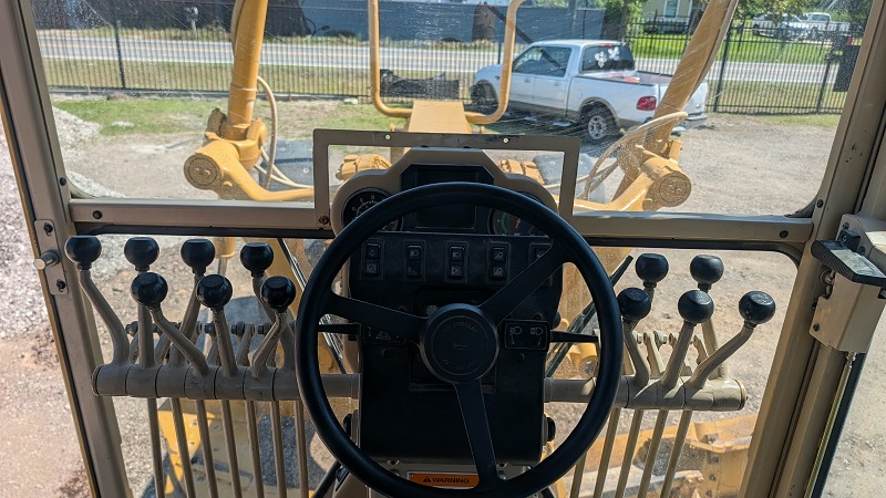 1999 Caterpillar 140H Motor Grader Operator Cab Interior Steering Wheel and Control Levers